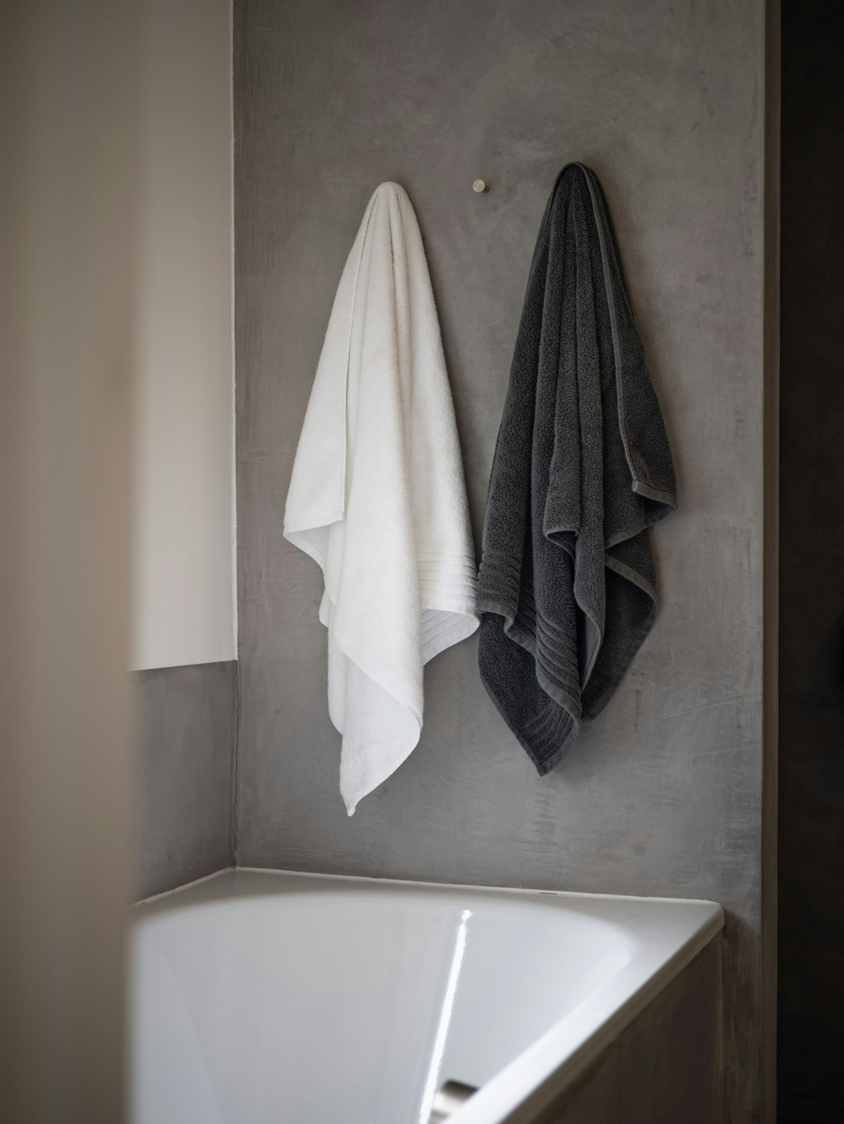 Towels hanging above a white bathtub