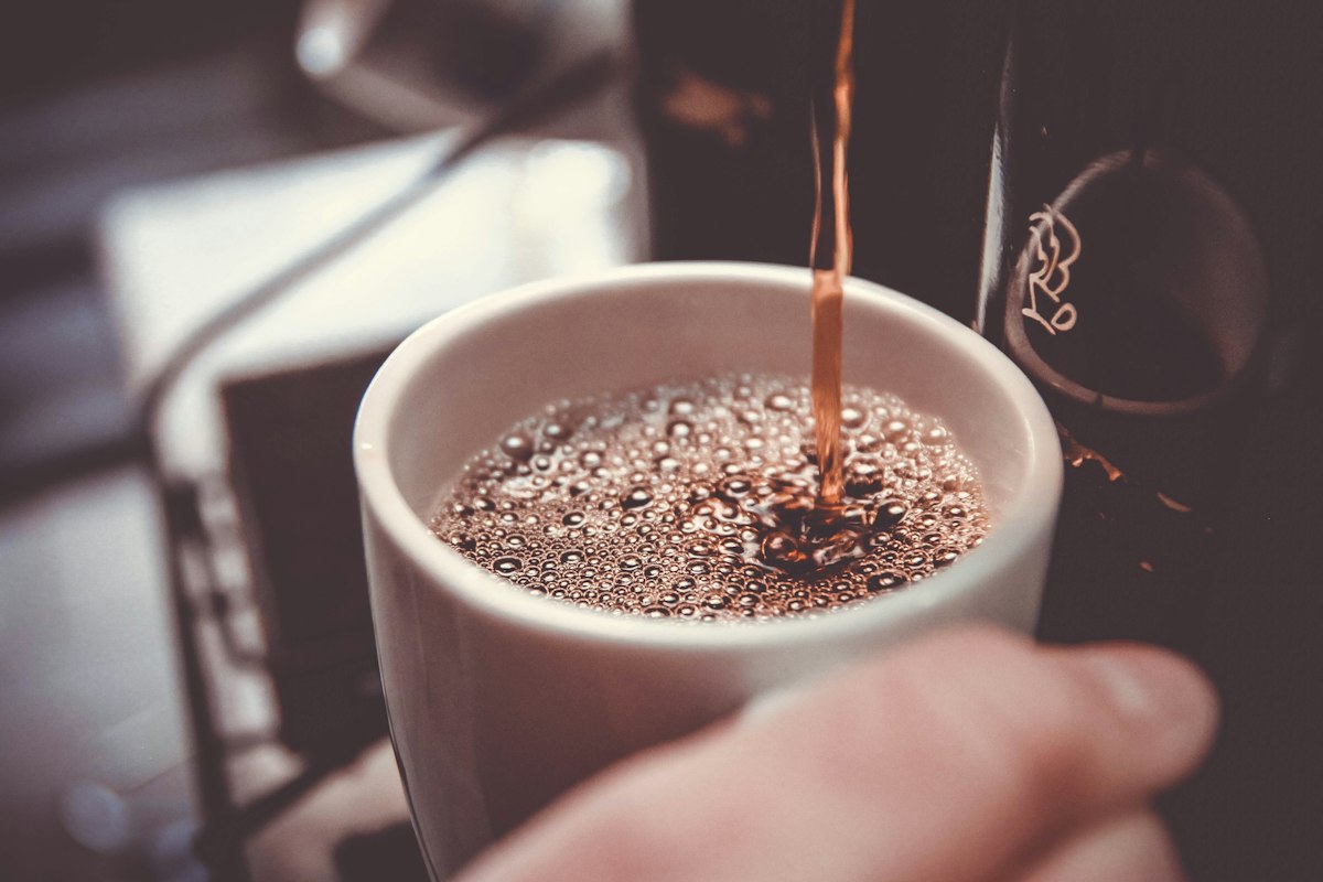 Coffee being poured into a white mug