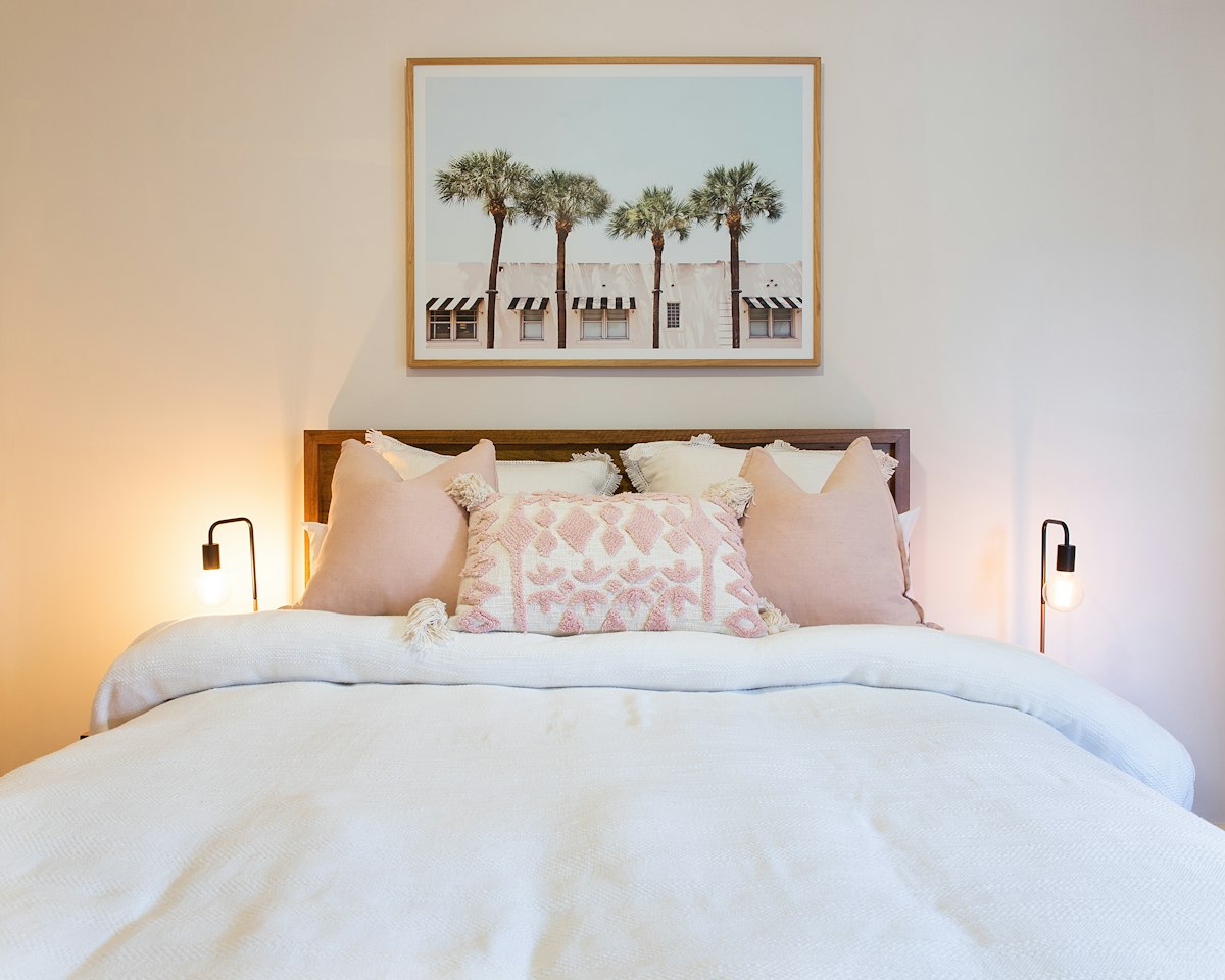 Bedroom with lit wall lamps on both sides of the bed
