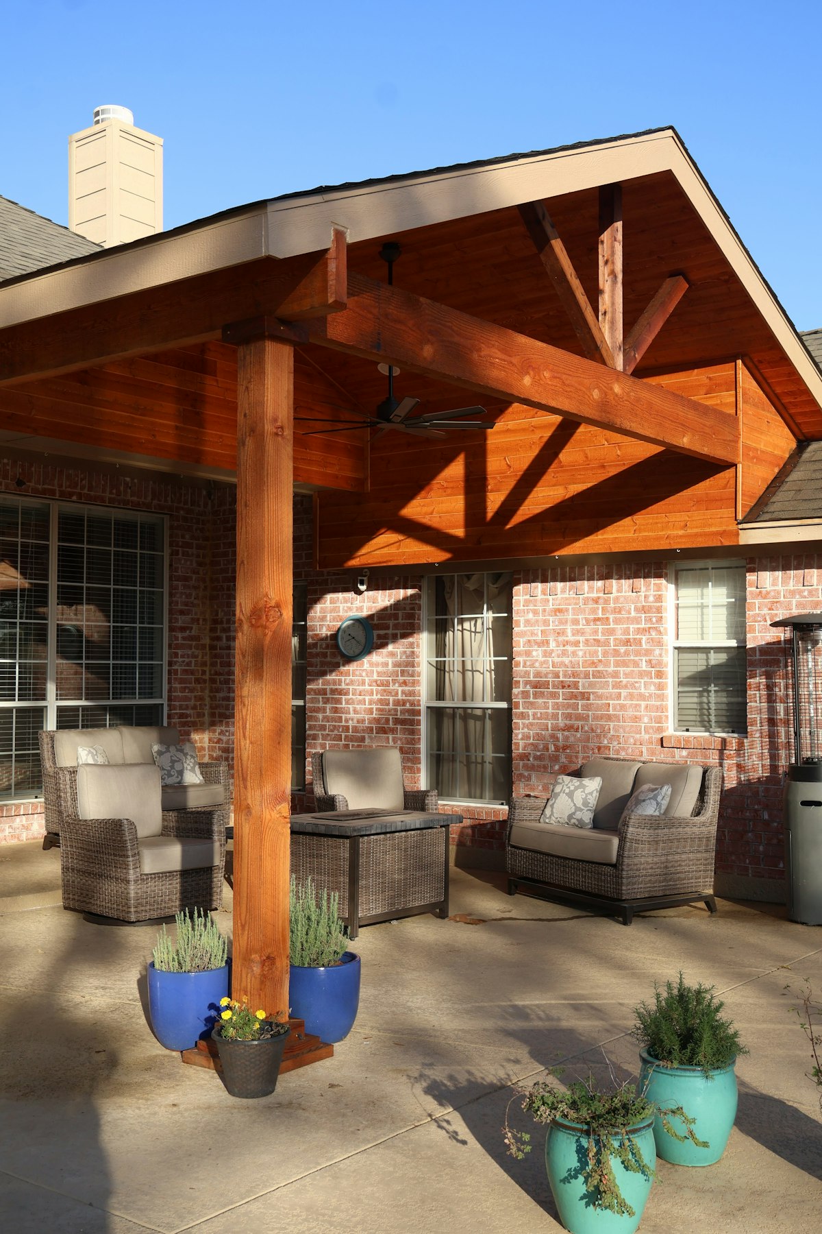 Backyard patio with a pergola and wicker seating