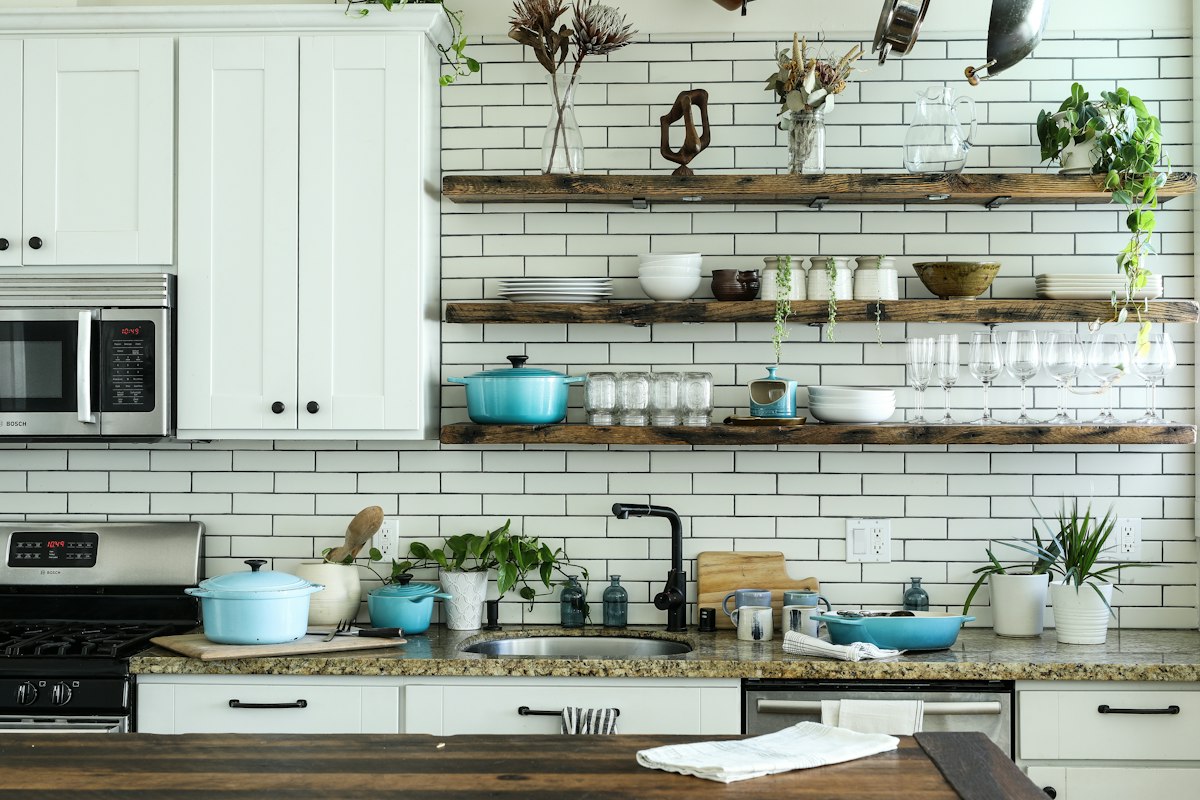 Kitchen counters with a microwave, stove, and open shelving